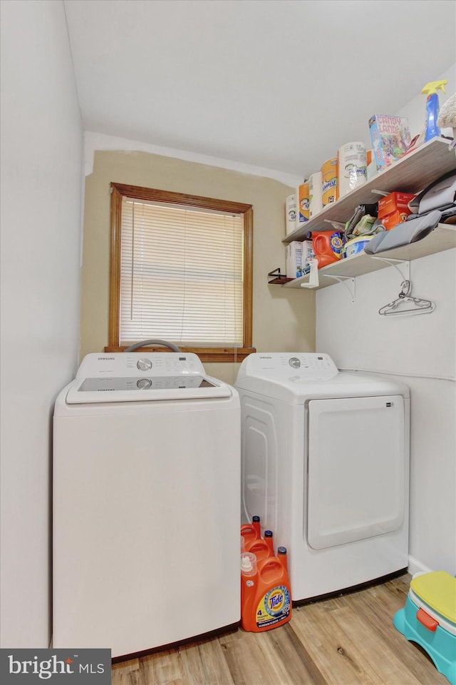 laundry area with separate washer and dryer, laundry area, and light wood-type flooring