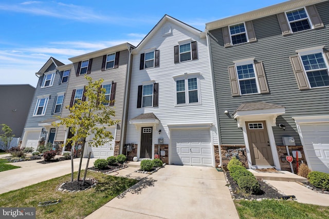 townhome / multi-family property with a garage and concrete driveway