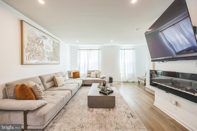 living area with recessed lighting, baseboards, and wood finished floors