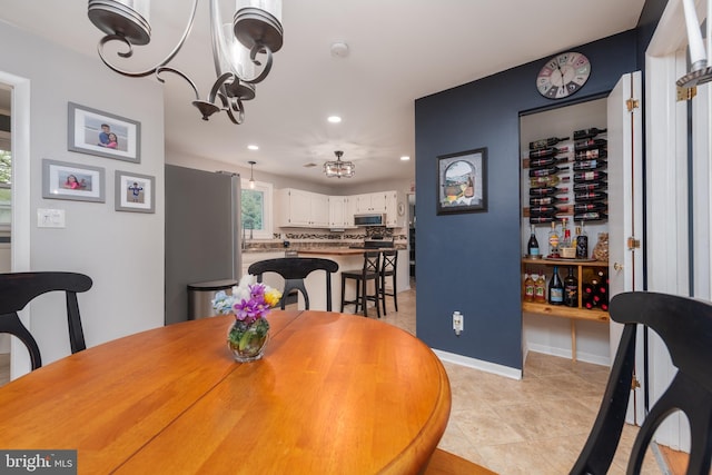 dining space with baseboards, an inviting chandelier, light tile patterned flooring, and recessed lighting