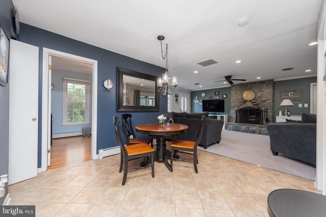 dining area with recessed lighting, a stone fireplace, light tile patterned floors, baseboard heating, and ceiling fan with notable chandelier