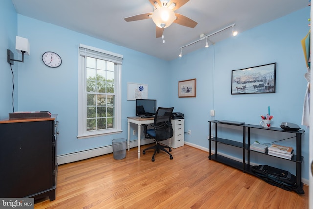 office area with a baseboard radiator, ceiling fan, light wood finished floors, rail lighting, and baseboards