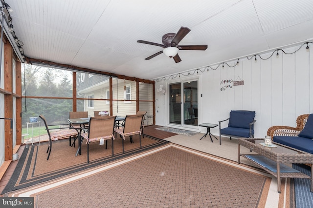 sunroom / solarium featuring a ceiling fan and outdoor dining space