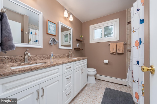 bathroom featuring a baseboard radiator, double vanity, baseboards, and a sink