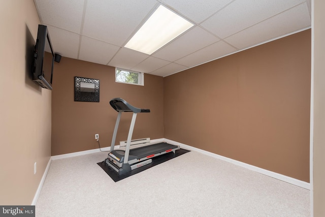 exercise area with a baseboard heating unit, carpet, a drop ceiling, and baseboards