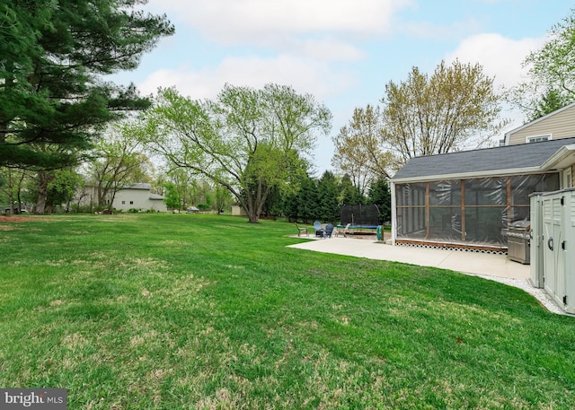 view of yard with a trampoline, a sunroom, and a patio