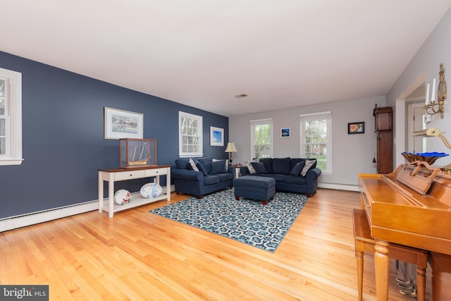 living area with a baseboard heating unit, wood finished floors, and a baseboard radiator