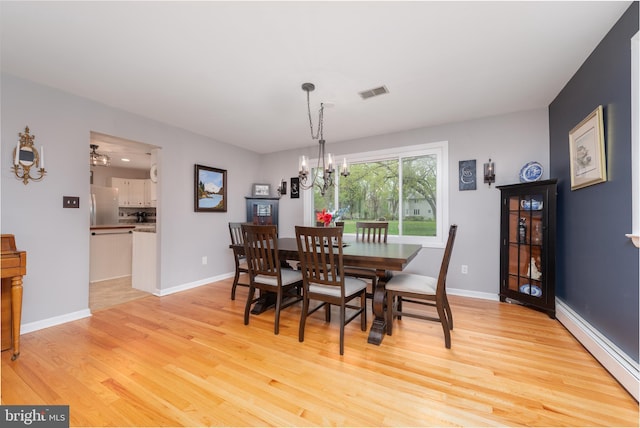dining room featuring light wood finished floors, baseboards, visible vents, an inviting chandelier, and a baseboard radiator