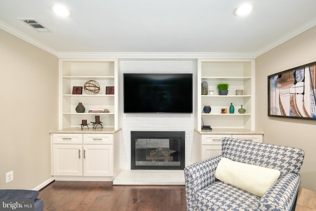 5580 Ann Peake Dr, Fairfax, VA 22032 - living room with visible vents, ornamental molding, a glass covered fireplace, built in features, and dark wood-style flooring