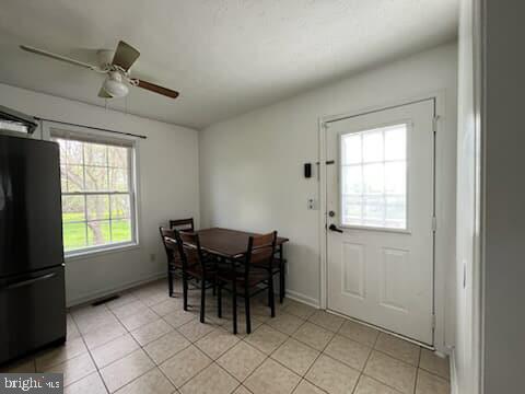 dining room with ceiling fan, baseboards, and light tile patterned floors