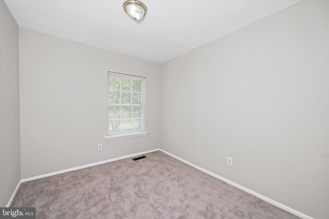 unfurnished room featuring carpet floors, visible vents, and baseboards