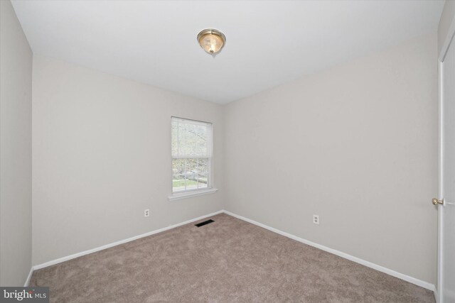 carpeted spare room with baseboards and visible vents