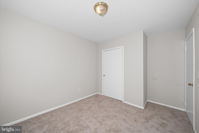unfurnished bedroom featuring baseboards, a closet, and carpet