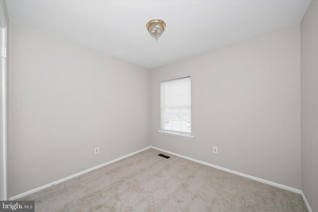 spare room featuring visible vents, baseboards, and carpet floors
