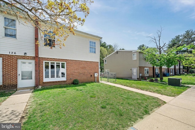 exterior space with brick siding and a yard