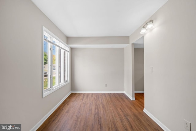 empty room with baseboards and wood finished floors