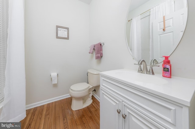 full bathroom featuring baseboards, vanity, toilet, and wood finished floors