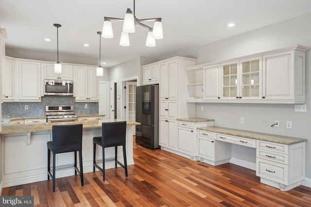 kitchen with open shelves, stainless steel appliances, white cabinetry, and a breakfast bar area