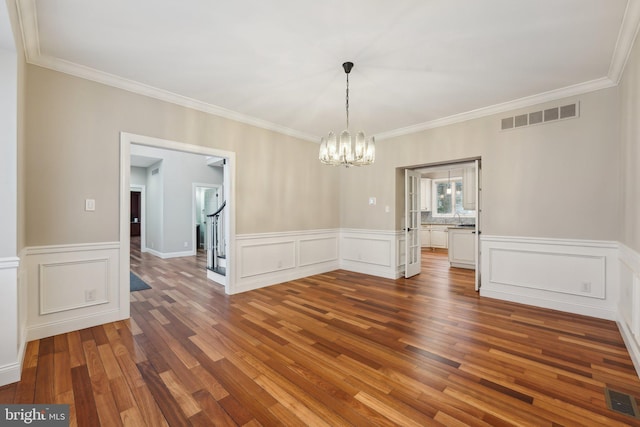 unfurnished dining area with crown molding, a chandelier, and visible vents