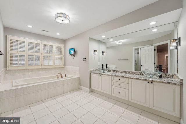 full bath with a garden tub, a sink, double vanity, and recessed lighting