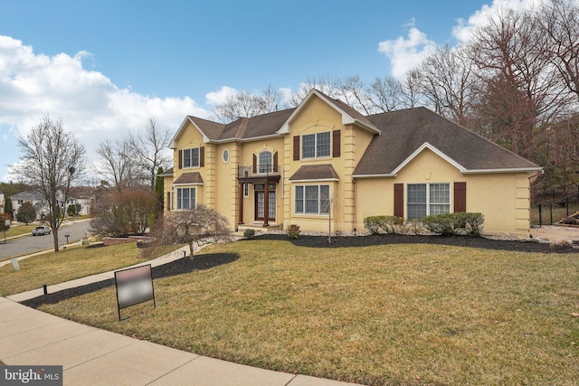 traditional-style house featuring stucco siding, roof with shingles, and a front yard