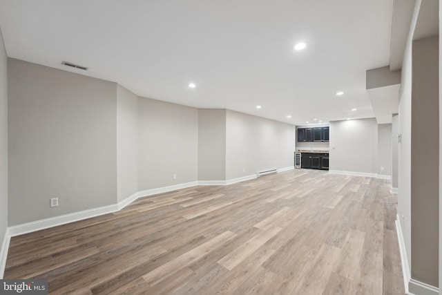 unfurnished living room with light wood-type flooring, baseboards, visible vents, and recessed lighting