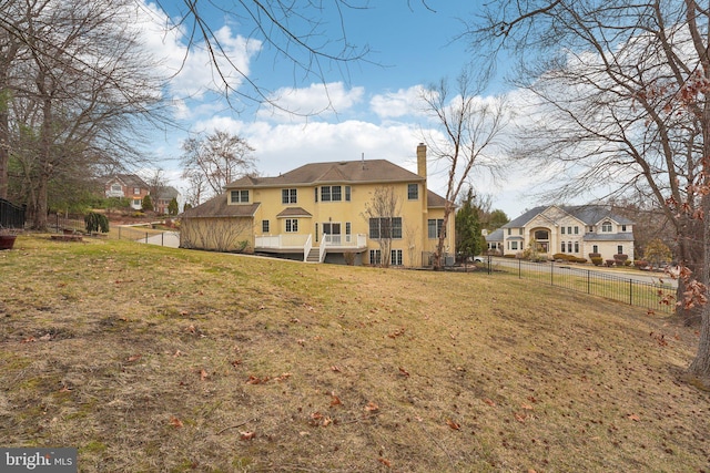 rear view of property with a yard, a fenced backyard, a chimney, and stucco siding