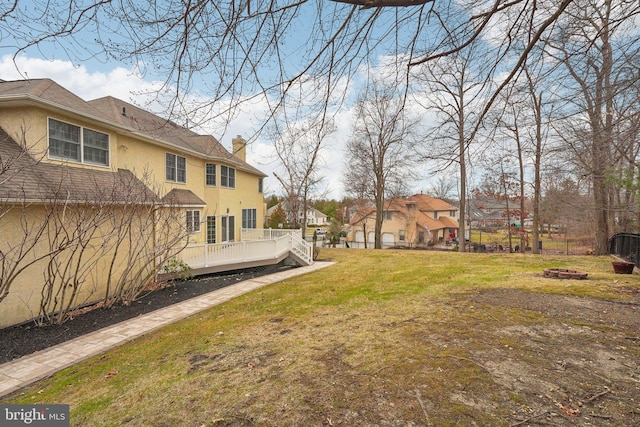 view of yard with a fire pit, a residential view, and a deck