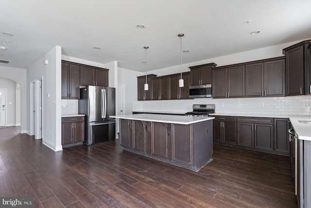 4507 Shakespeare Cir, White Plains, MD 20695 - kitchen with stainless steel appliances, arched walkways, dark brown cabinets, and a center island