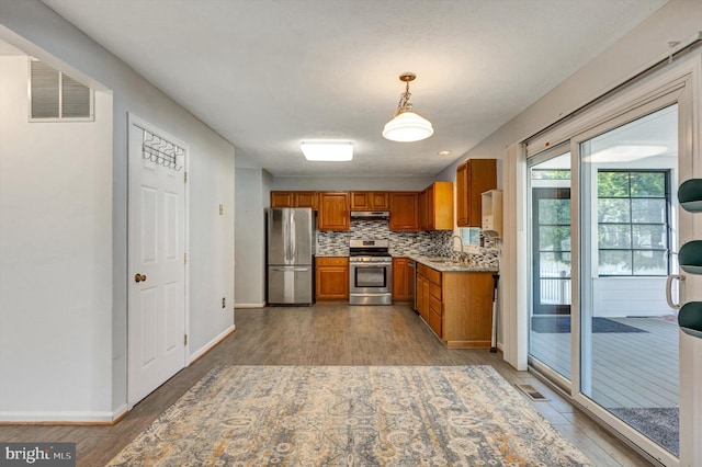 9208 Homestretch Ct, Laurel, MD 20723 - kitchen featuring brown cabinetry, backsplash, visible vents, appliances with stainless steel finishes, and a sink