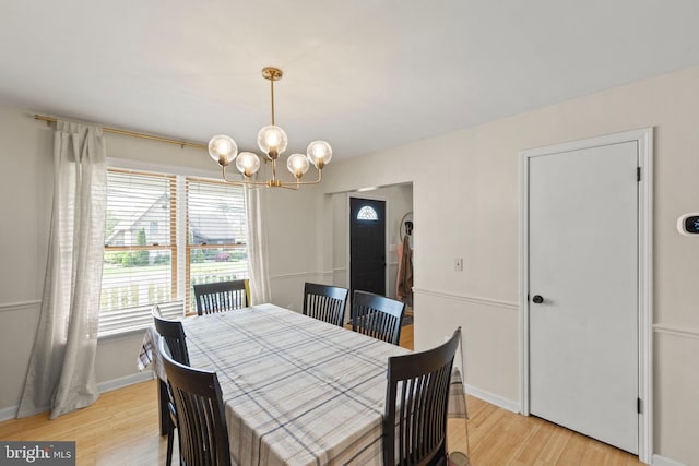 dining room featuring a chandelier, baseboards, and light wood-style flooring