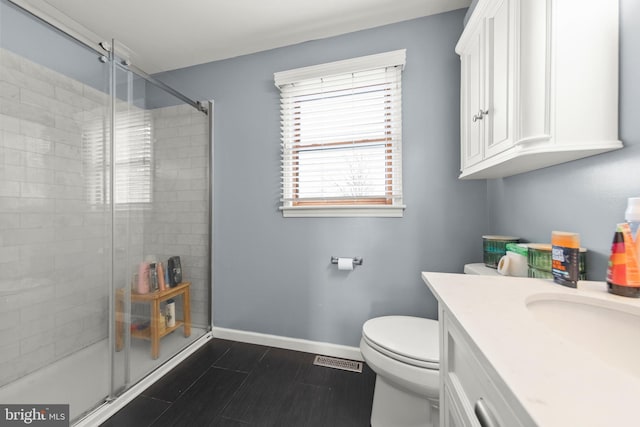 full bath with a shower stall, vanity, toilet, visible vents, and baseboards