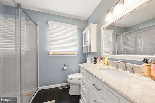 full bathroom featuring baseboards, a stall shower, toilet, and vanity