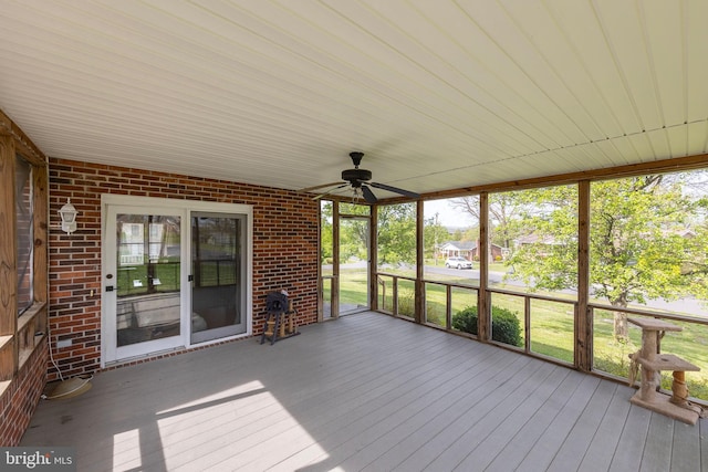 unfurnished sunroom with a ceiling fan and plenty of natural light