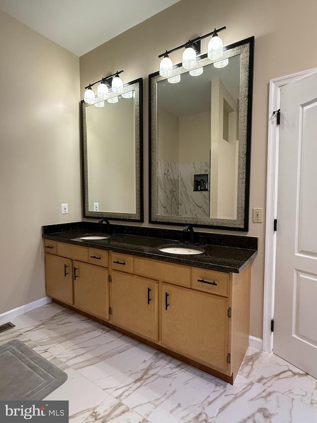 full bathroom with a sink, baseboards, double vanity, and marble finish floor