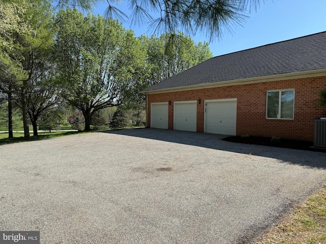 garage featuring cooling unit and driveway