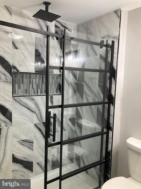 interior space with toilet and a stall shower