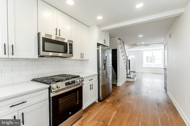 kitchen featuring white cabinets, light wood finished floors, and stainless steel appliances