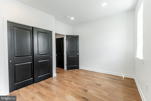 unfurnished bedroom with recessed lighting, baseboards, and light wood-type flooring