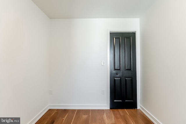 spare room featuring wood finished floors and baseboards
