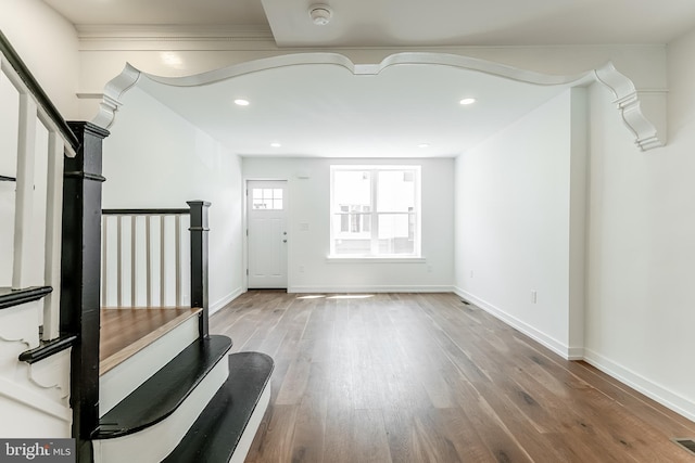 interior space with baseboards, wood finished floors, and recessed lighting