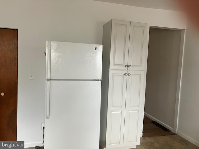 kitchen with baseboards, freestanding refrigerator, and visible vents