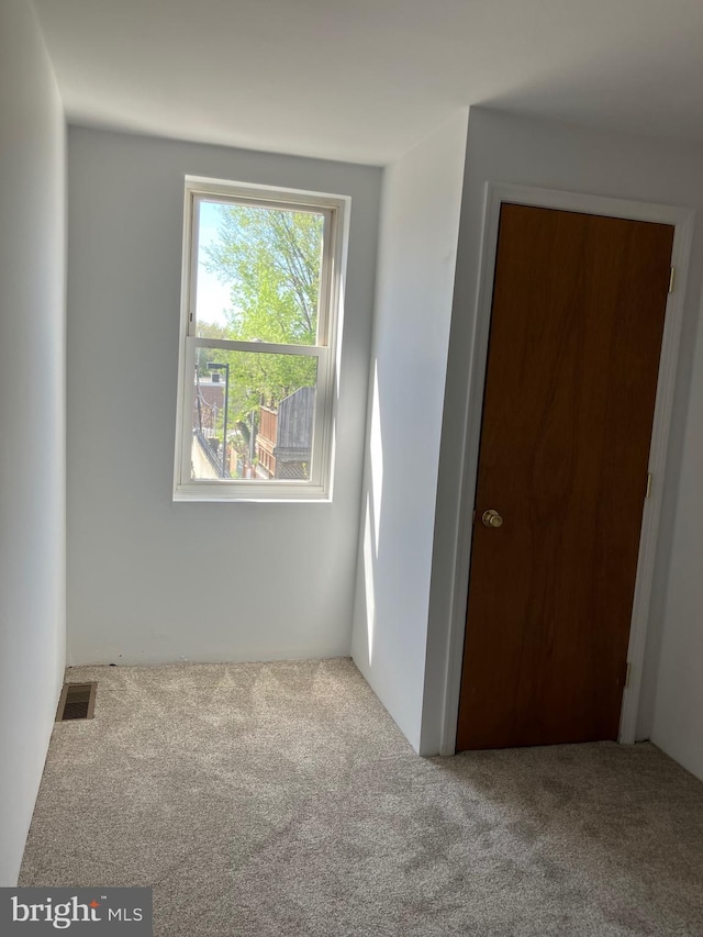 empty room with carpet flooring and visible vents