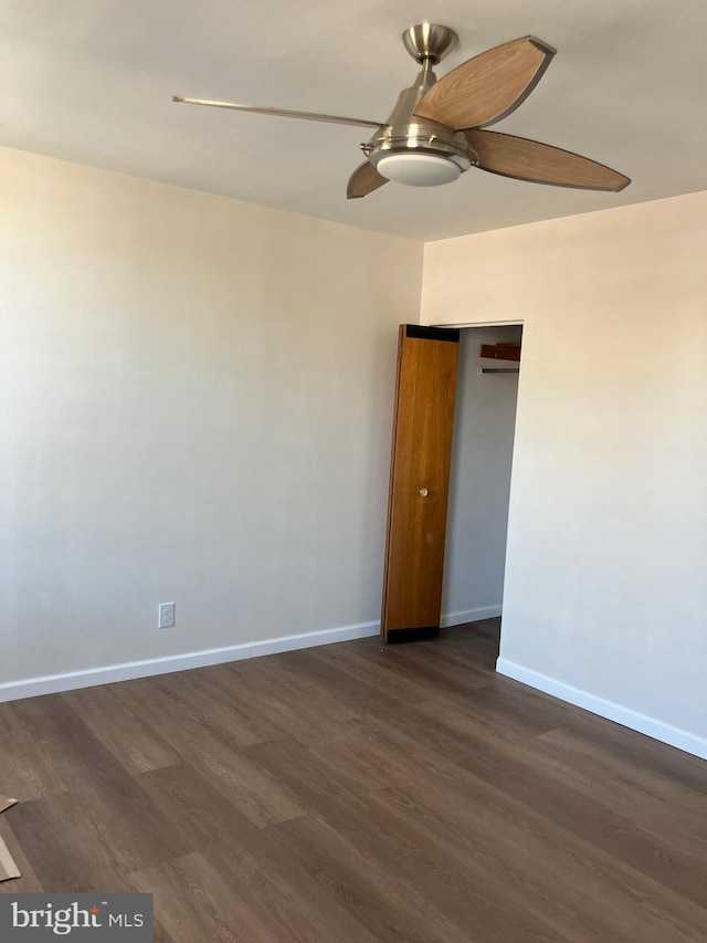 spare room featuring dark wood-type flooring, baseboards, and ceiling fan