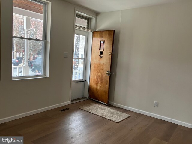 entrance foyer with baseboards, wood finished floors, and visible vents