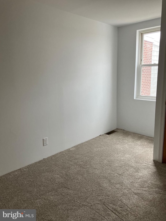 spare room featuring carpet floors and visible vents