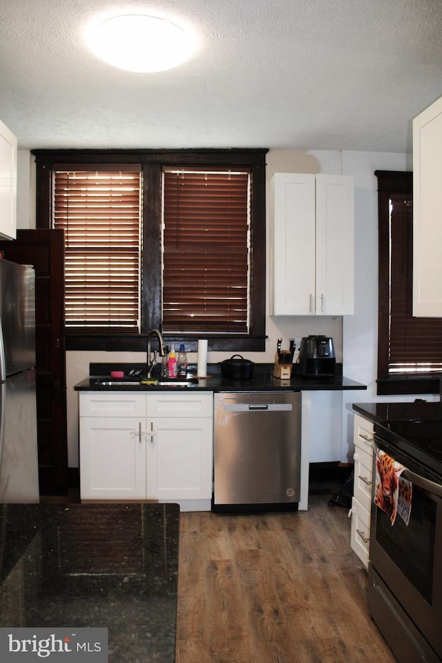 408 Prince George St, Cumberland, MD 21502 - kitchen with appliances with stainless steel finishes, a sink, a textured ceiling, dark countertops, and white cabinetry