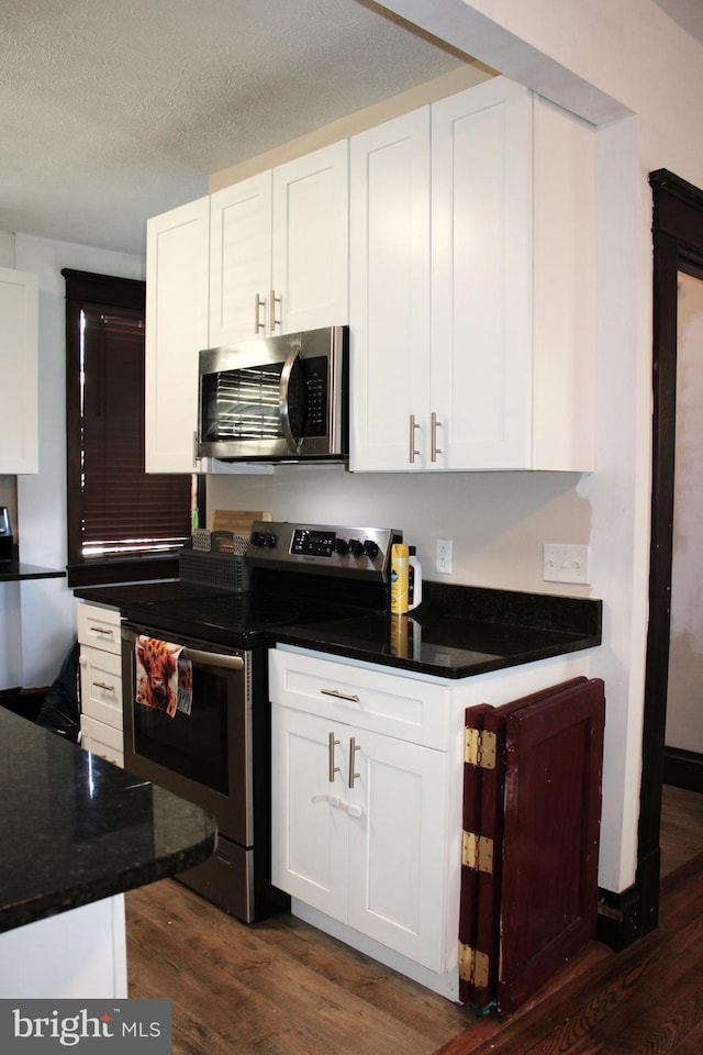 408 Prince George St, Cumberland, MD 21502 - kitchen with appliances with stainless steel finishes, dark wood-style flooring, white cabinetry, and a textured ceiling