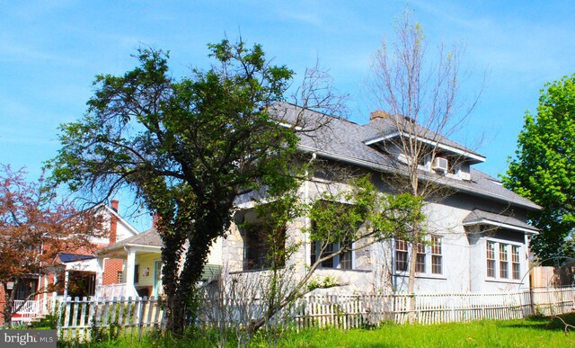 408 Prince George St, Cumberland, MD 21502 - view of side of property featuring a fenced front yard, stone siding, and a shingled roof