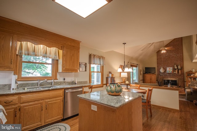 kitchen with a sink, a fireplace, a healthy amount of sunlight, and dishwasher